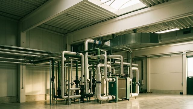 Réseau de tuyauteries et échangeur de récupération de chaleur dans un local technique.